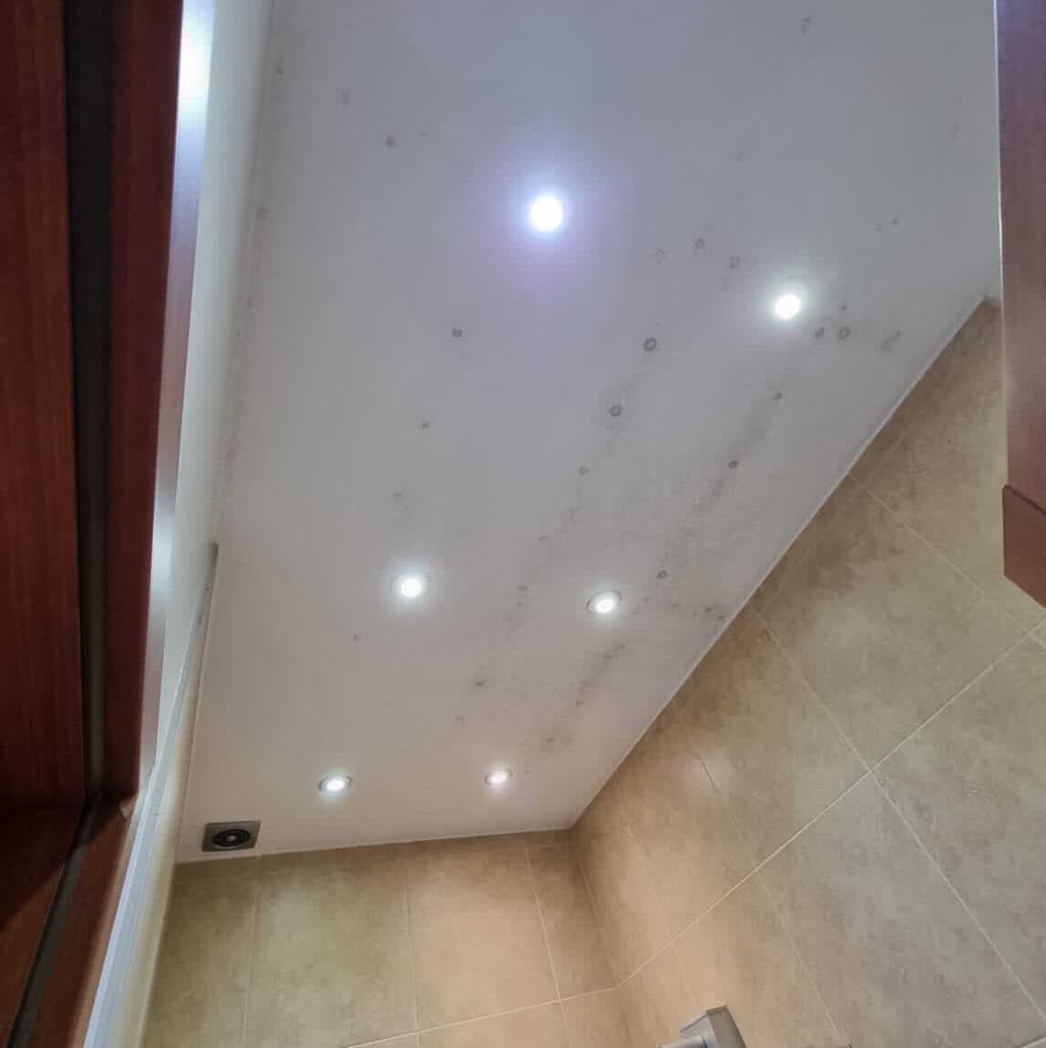 Bathroom ceiling with mould spots, before treatment